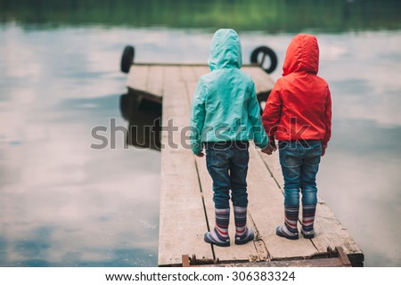 two little sisters, twins are on the Wooden bridge