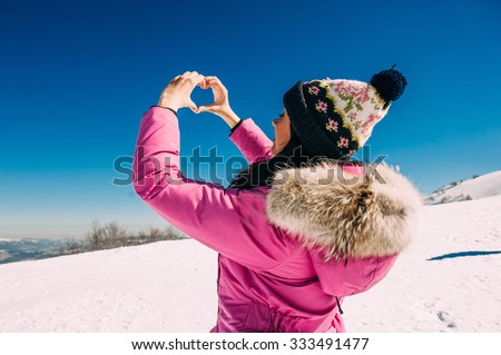 Beautiful stylish woman in snowy mountains, cute girl  of high mountain covered with snow, winter vacation concept
