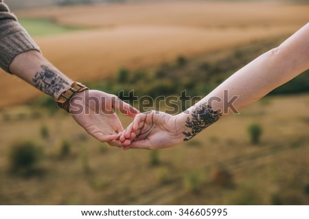 hand couples with identical tattoos