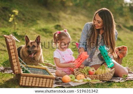 mother and daughter at a picnic with a German shepherd dog