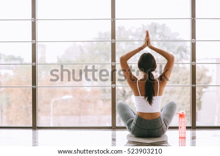 Girl with a bottle of water by the window in the gym