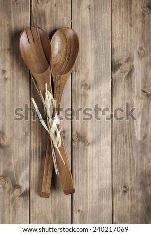 brown wooden spoon with a fork for the salad on the table from the old boards