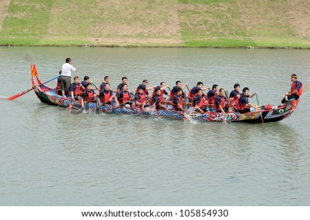 YILAN TAIWAN - JUNE 23: A team of rowers returning to the starting line for the dragon boat race.  Erlong Dragon boat racing festival on the Erlong River on June 23, 2012 in Yilan