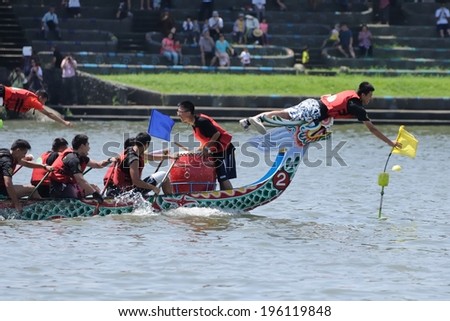 YILAN TAIWAN - JUNE 1: yellow team\'s flag fetcher first snatched the flag at the end point. The Dragon Boat Festival on the Dongshan River on June 1, 2014 in Yilan