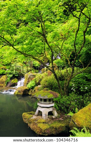 a rock lantern in japanese garden surrounding with trees