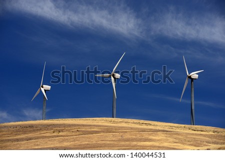 wind power farm on grass hill with blue sky