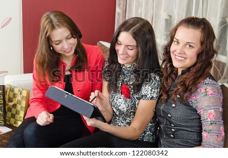 Group young women friends chatting at home and using laptop to look at new photo or browsing internet