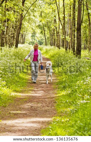 The woman walks with a dog