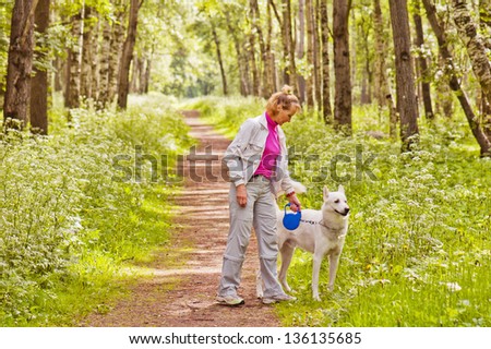 Woman walks with a dog in a wood