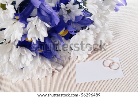 A bunch of flowers and wedding rings