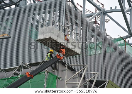 SELANGOR, MALAYSIA - NOVEMBER 27 2015: Construction workers using the mobile crane basket while working high level at the construction site in Malaysia