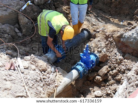 Construction workers install underground utility and services pipe. Trenches was dig to the required level for them to lay the pipes.