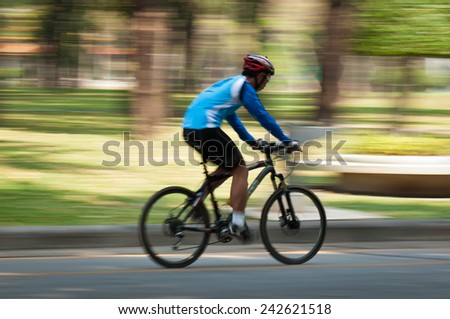 Motion blur of a bike rider in public park
