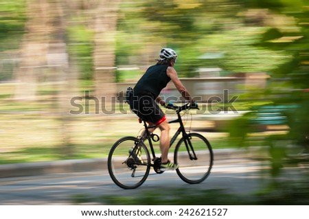 Motion blur of a bike rider in public park