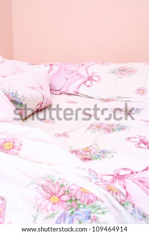 Double bedroom with pink messy sheet .