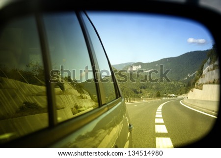 Highway viewed in car mirror.