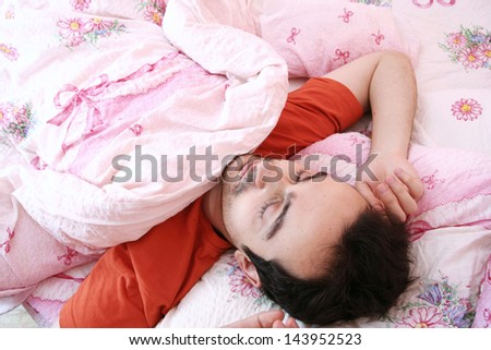 Young man sleeping in bed .