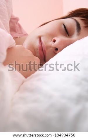 Beautiful young woman sleeping on bed in her bedroom at home in the morning.