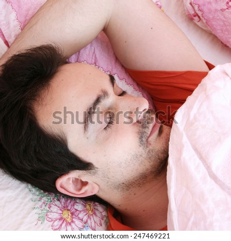 Young man sleeping in bed .