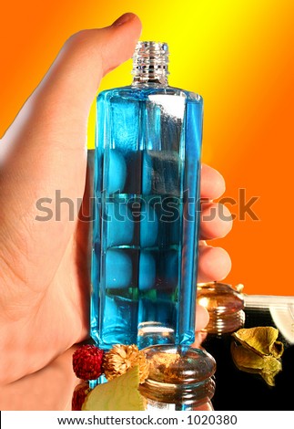 Bottle of Parfume in Hand - Isolated on orange background