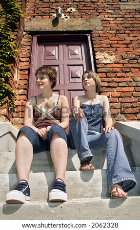 Two girls laying on the stairs in front of the hause