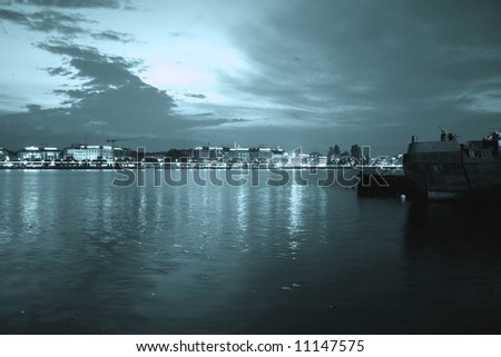 Panorama of modern city at night. Water reflection.