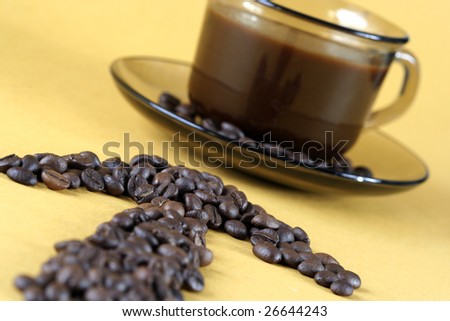 Cup with coffee, costing on coffee grain.