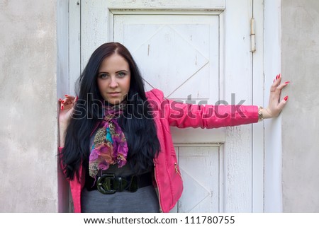 A beautiful girl standing in front of the closed white door.