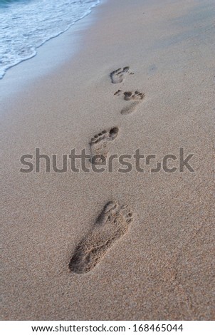 Footprint on sand with foam - beach, wave and footsteps