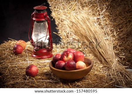 red apples on straw with red gas lamp