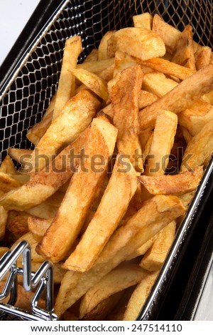 Freshly baked french fries in an electric frying pan basket
