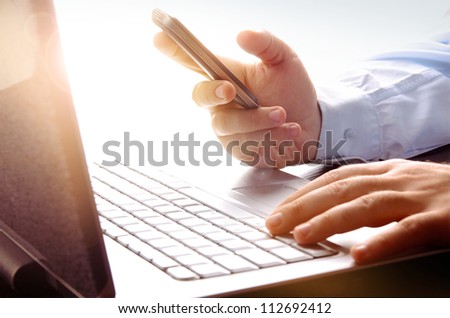 Businessman Using Laptop And Mobile Phone