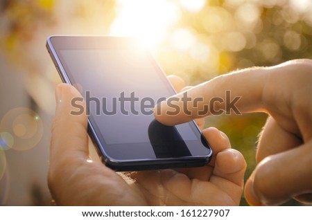 Close up of a man using mobile smart phone outdoor