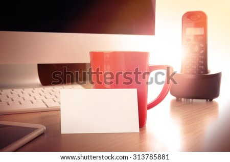 Office desk table with a blank business card. Concept for website contact page and banner, printed material or presentation with company or personal contact informations.