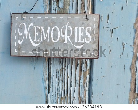 Shabby chic metal memories sign hanging on grunge blue painted wood