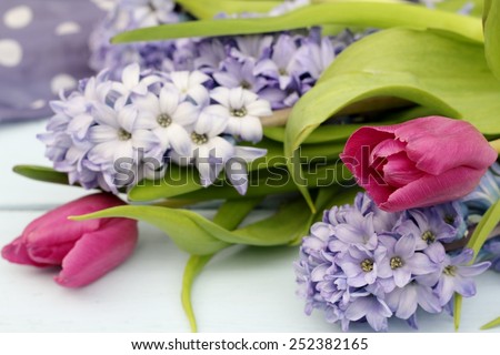 Blue, lilac hyacinth and dusky pink tulips i on wooden pale duck egg blue painted wooden boards , pretty spring image , shallow depth of field , mothers day