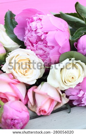 Pink and cream flowers, roses and peonies, on wooden bench with bright pink wood back ground, shabby chic floral arrangement