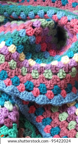Crochet blanket, a wool handmade afghan blanket, made using granny stitch with blue, pink, cream, green and purple yarn