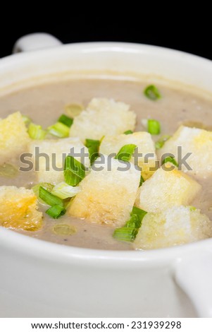 close up of mushroom soup and bread in white ceramic cup