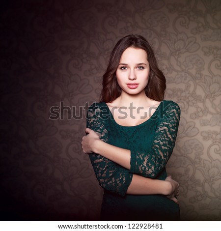 Portrait of young attractive woman with dark hair. Vintage background in studio.