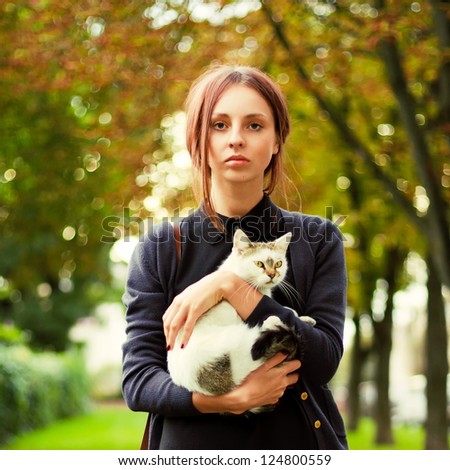 Outdoor fashion Portrait of young beautiful woman with little cat
