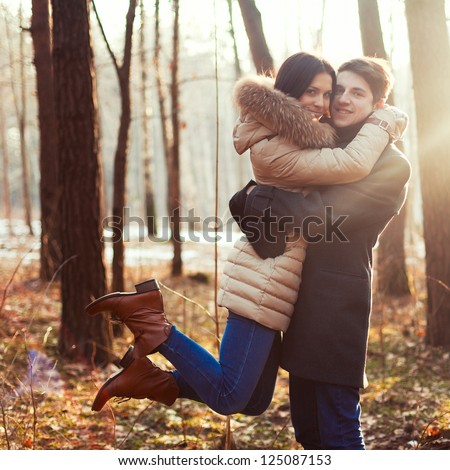 Spring Outdoor Portrait Of Young Pair. Boy And Girl In The Spring Forest Sitting On Vintage Cover