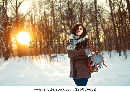 Young attractive girl posing in winter park. Bright sunshine colors