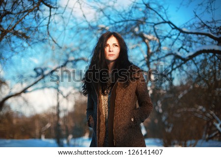 Fashion outdoor spring portrait of pretty girl in garden. Woman posing in winter park.