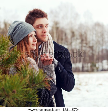 Outdoor sensual portrait of young beautiful couple in love standing and posing in cold spring forest