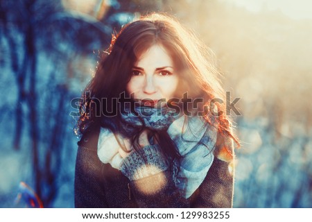 Outdoor portrait of young pretty beautiful woman in cold sunny winter weather in park. Sensual brunette posing and having fun