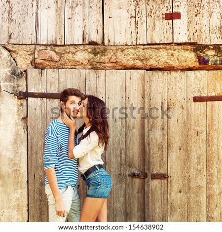 Young Beautiful Fashion Couple In Love Having Fun Outdoor In Summer. Girl Kiss Surprised Boy.