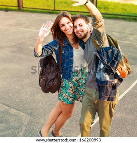 Young Pretty Funny Happy Smiling Couple Posing Outdoor On School Yard And Saying Hello And Having Fun Together In Love