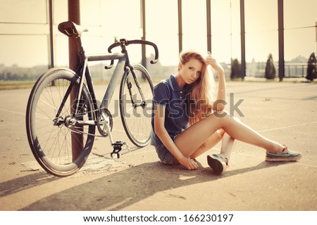 Young Pretty Blonde Woman Posing On The Street With Sport Fixed Gear Bike In Summer Sunshine. Fashion Portrait.