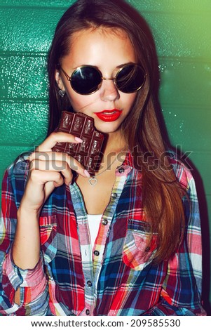 Outdoor night evening dark fashion closeup portrait of nice sensual pretty sexy brunette woman with seductive red lips and chocolate ready to eat and passion dressed vintage hipster style smile
